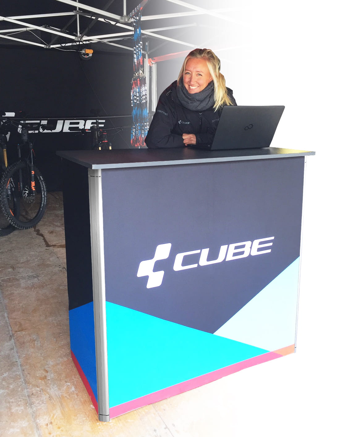 Messetheke Quickup Falttheke Premium von CUBE, besetzt von einer Person mit Laptop.