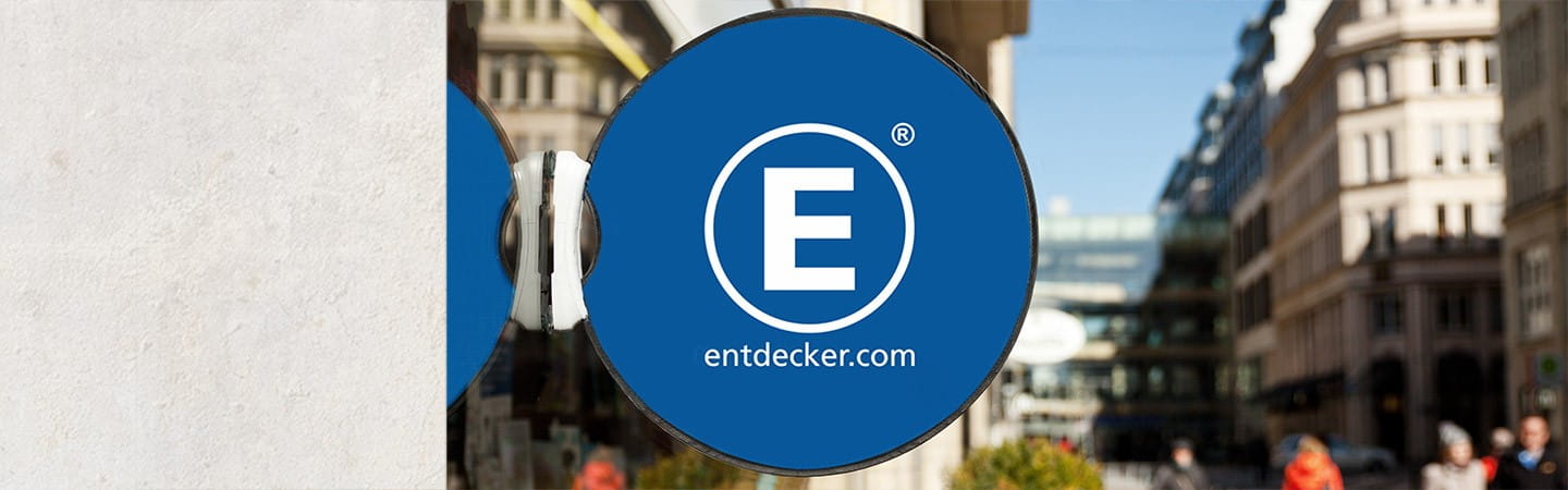 Werbedisplay Easydisc Flex von ENTDECKER an einer Schaufensterscheibe in einer Stadtansicht.