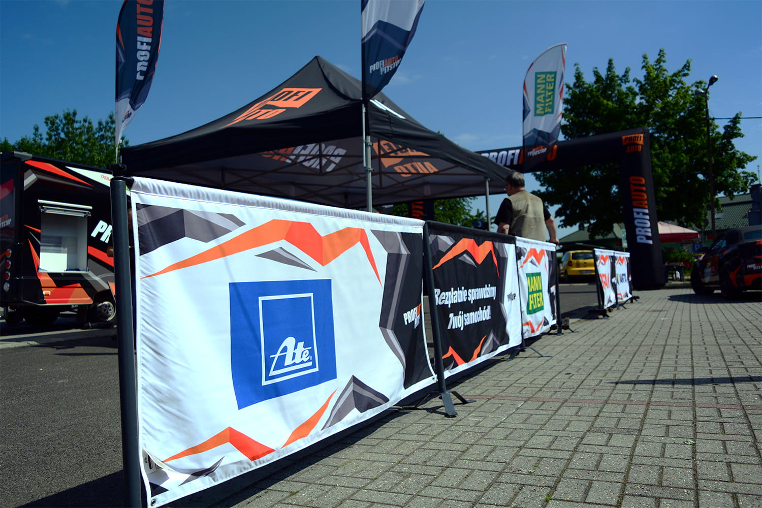 Zelt mit Werbebannern für die Rennsportbande Reihe und ATE, im Freien auf einem Event.