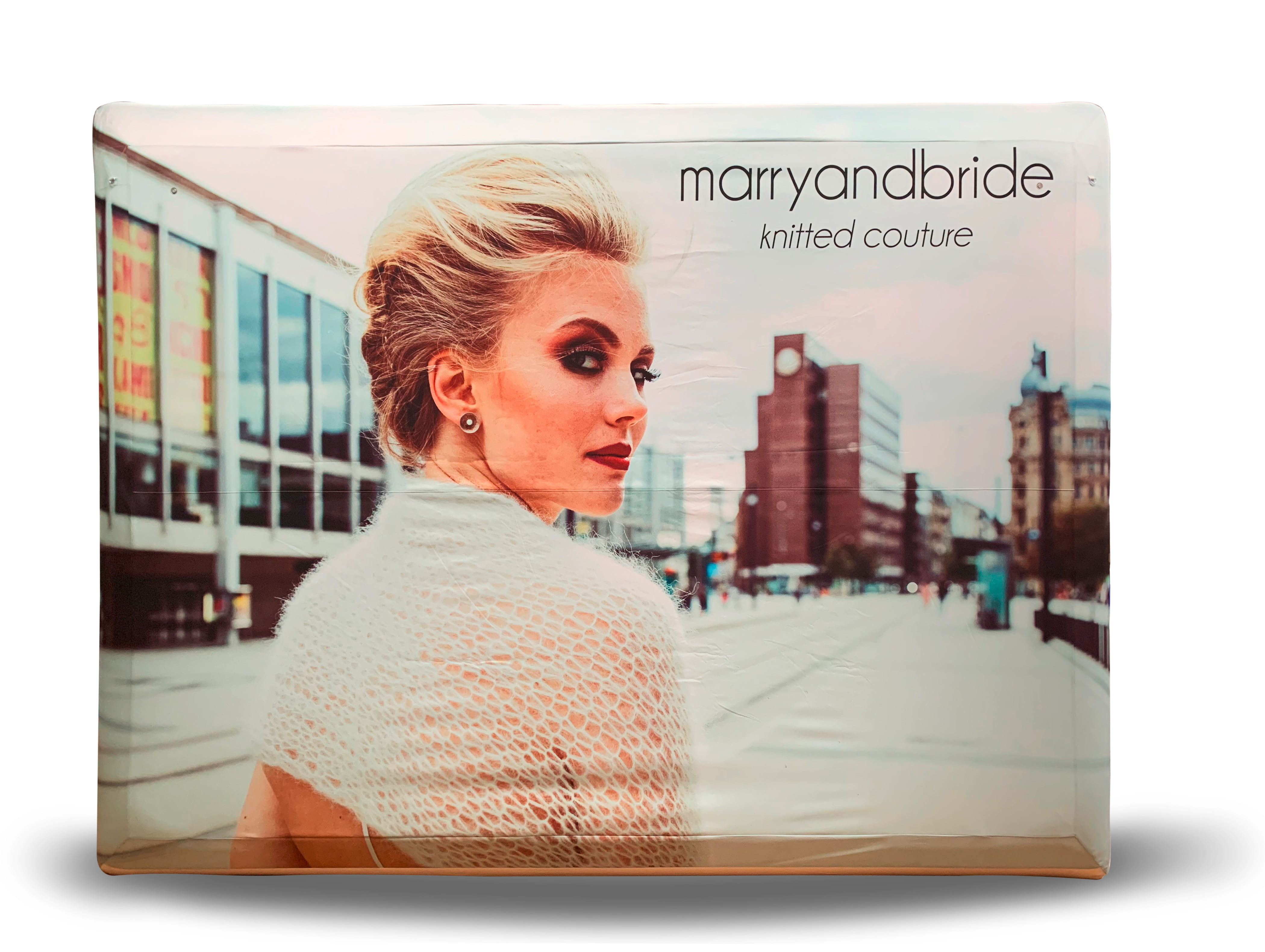 Wanddekoration mit dem Produktnamen 'marryandbride', zeigt eine Frau mit einem eleganten, gestrickten Outfit vor einer städtischen Kulisse.