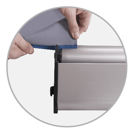 Detailansicht des Easywall Flex Kedersystems, das eine Person zeigt, die einen Stoff in das System einführt.