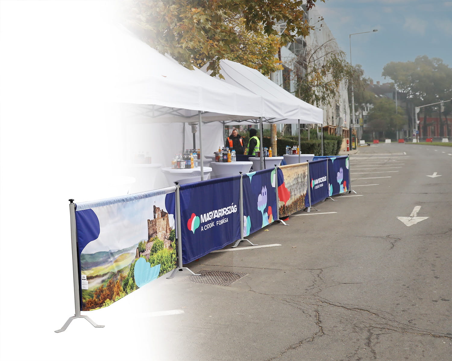 Rennsportbande in Reihe mit bunten Grafiken, auf einer Straße aufgestellt, um einen Eventbereich abzugrenzen.