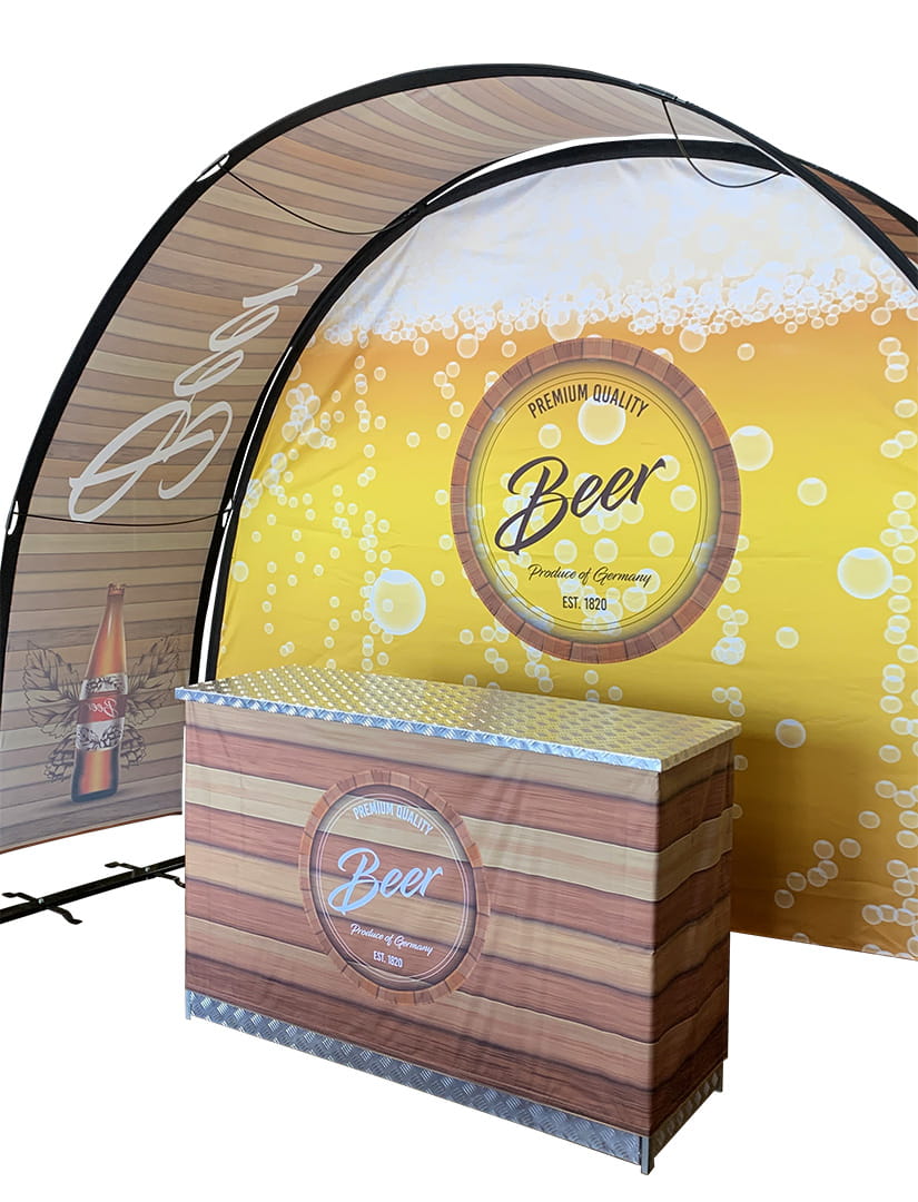 Eventbogen Messestand mit einem Holztheke und einem gelben Hintergrund mit dem Schriftzug 'Premium Quality Beer'.